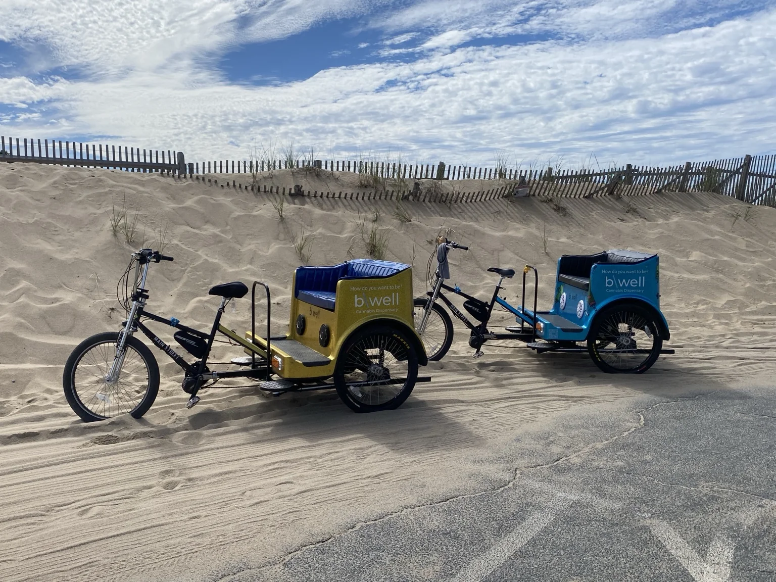 Two Commercial Street Pedicabs beside coastal dunes.
