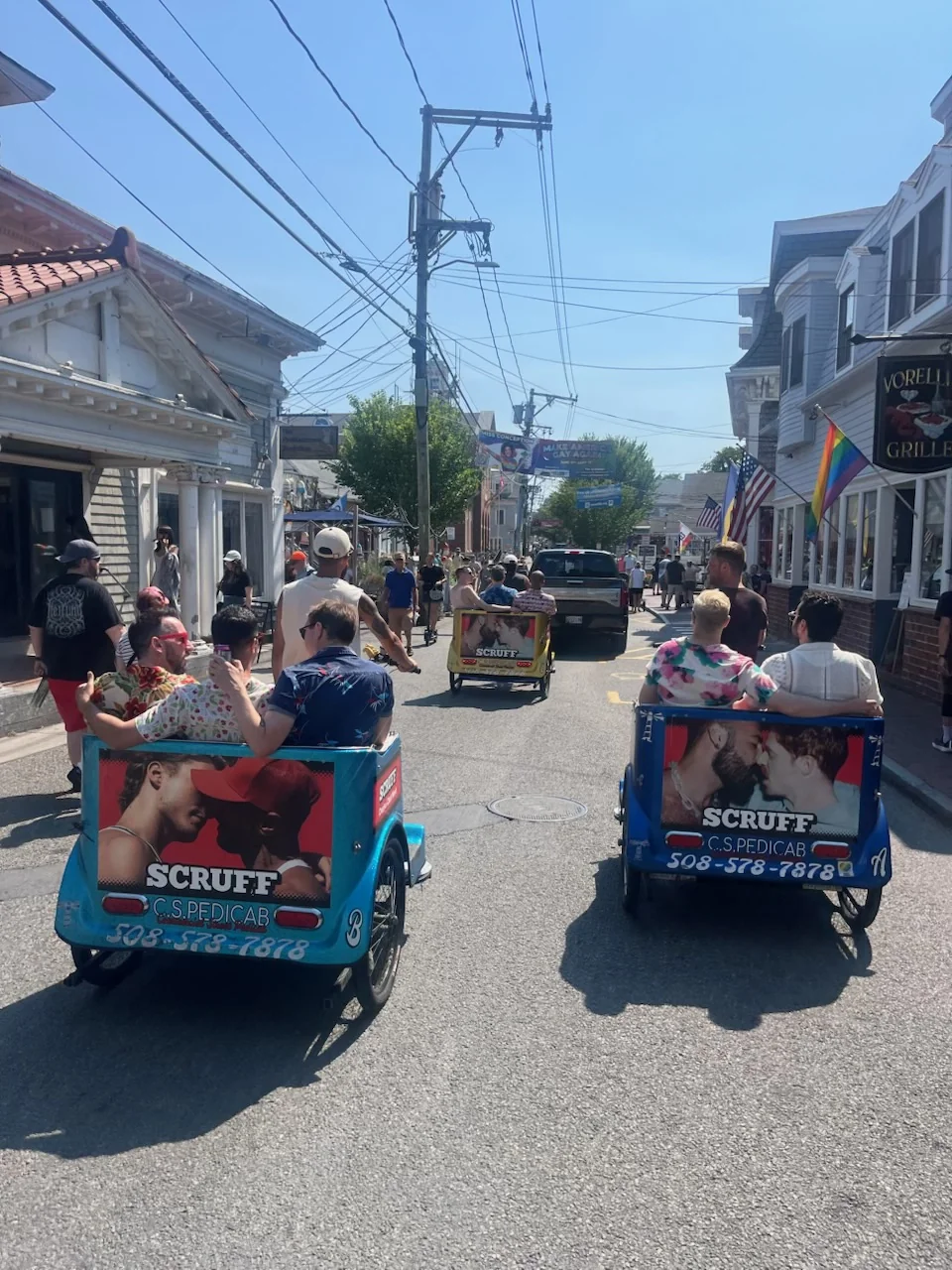 Guests riding together in pedicabs along Commercial Street.